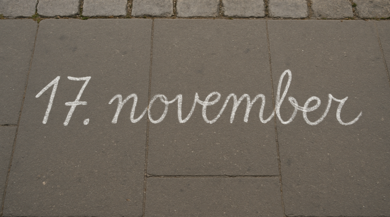 Chalk writing "17. november" on sidewalk.